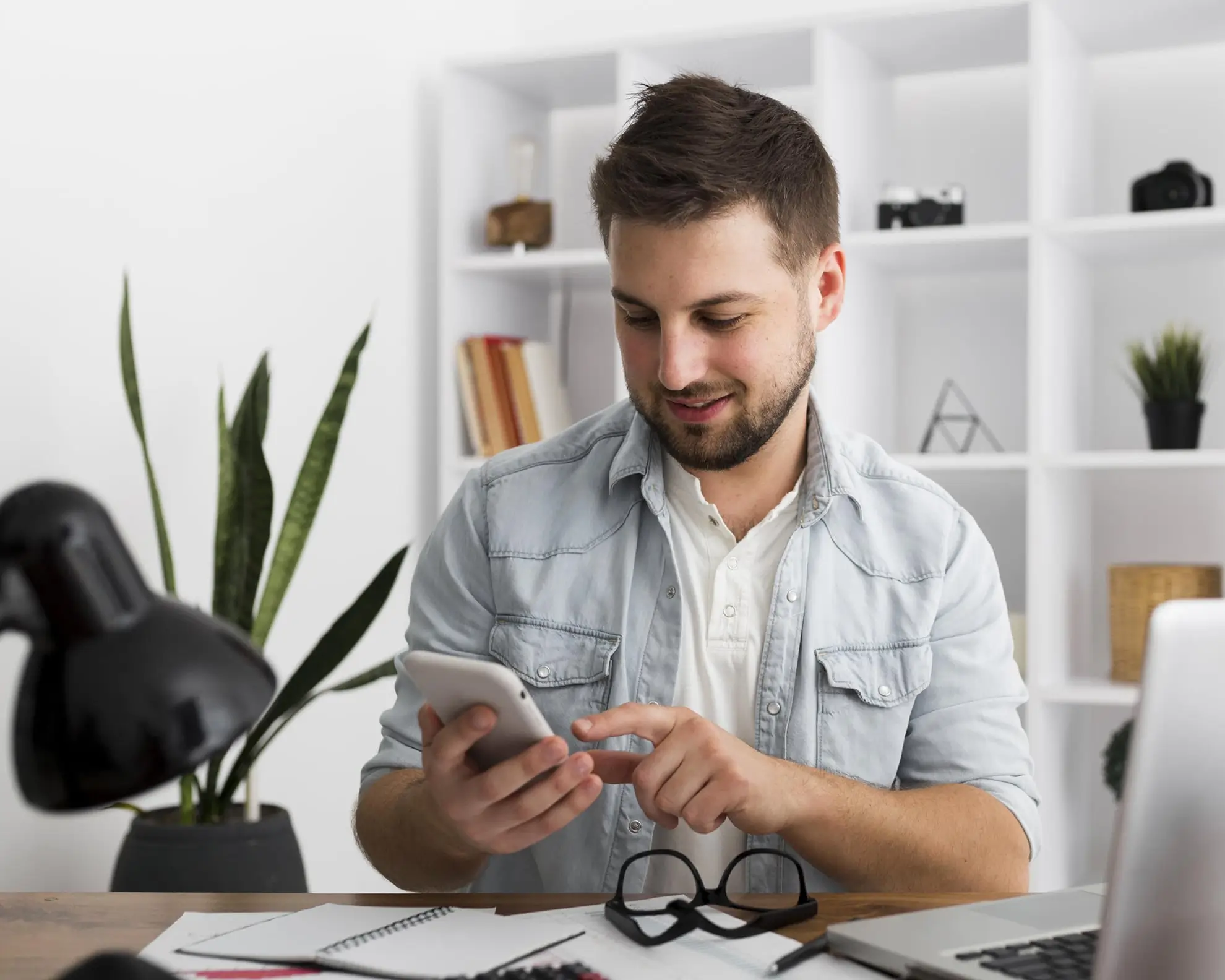 Homem empreendedor segurando celular dentro do escritório